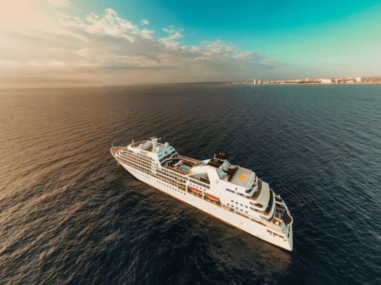 A cruise ships sails close to port.